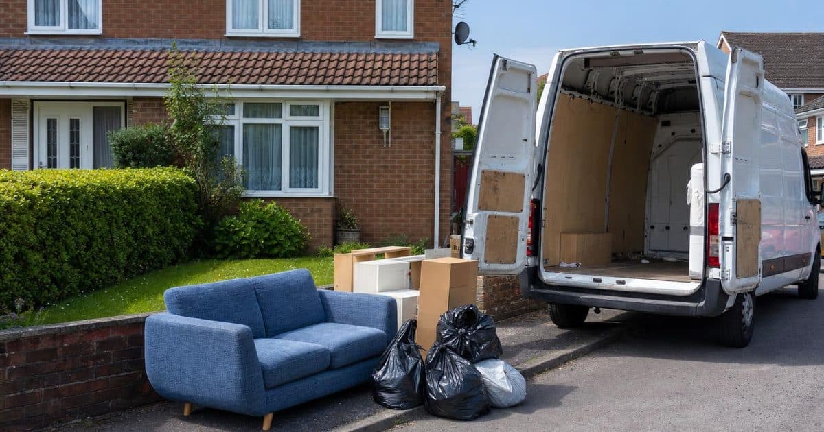 A van parked outside a semi-detached house in Andover with sorted items ready for clearance